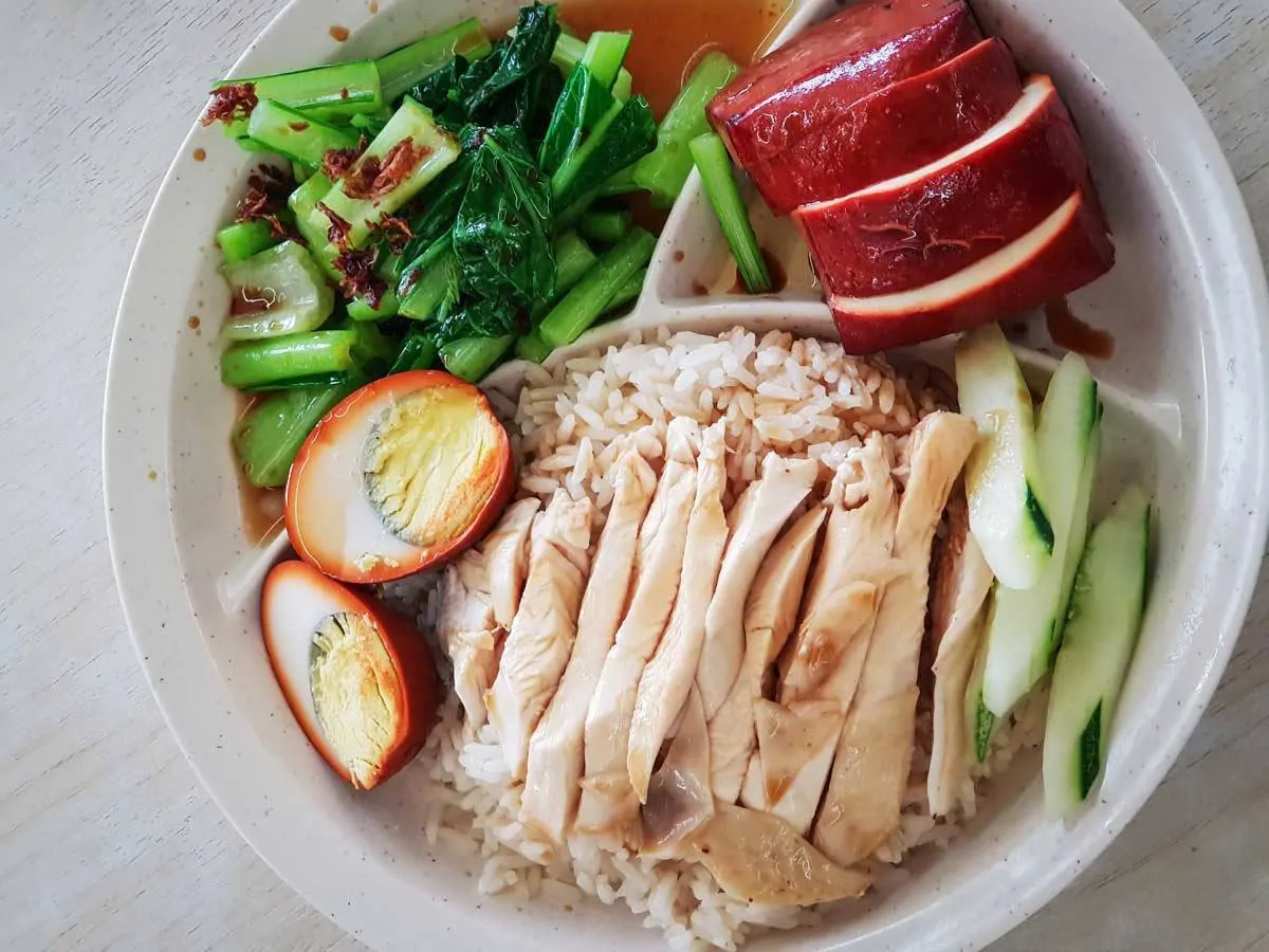 Plate of chicken and rice with egg and green veg. 