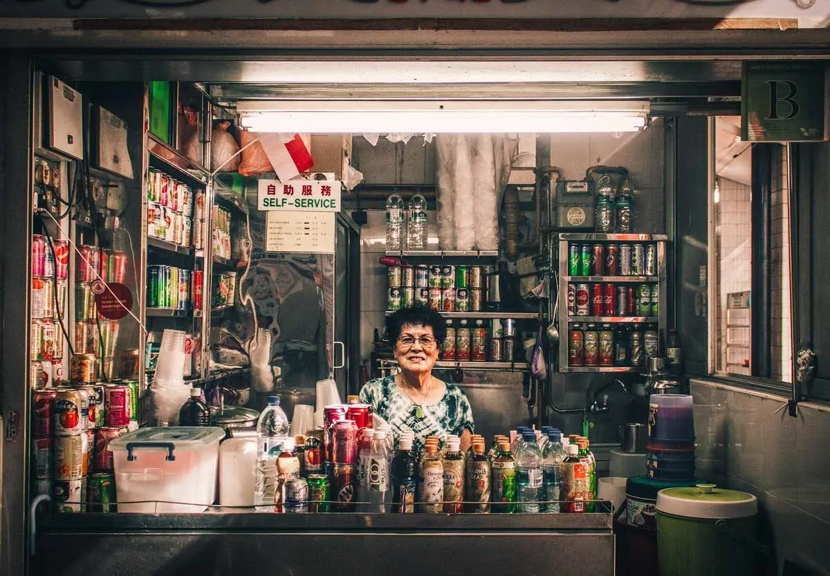 Women selling drinks from small stall. 