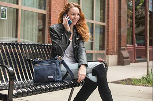 women sitting on park bench talking on her phone with a cross body purse sitting on the seat next to her. These are stylish cross body bags for travel.