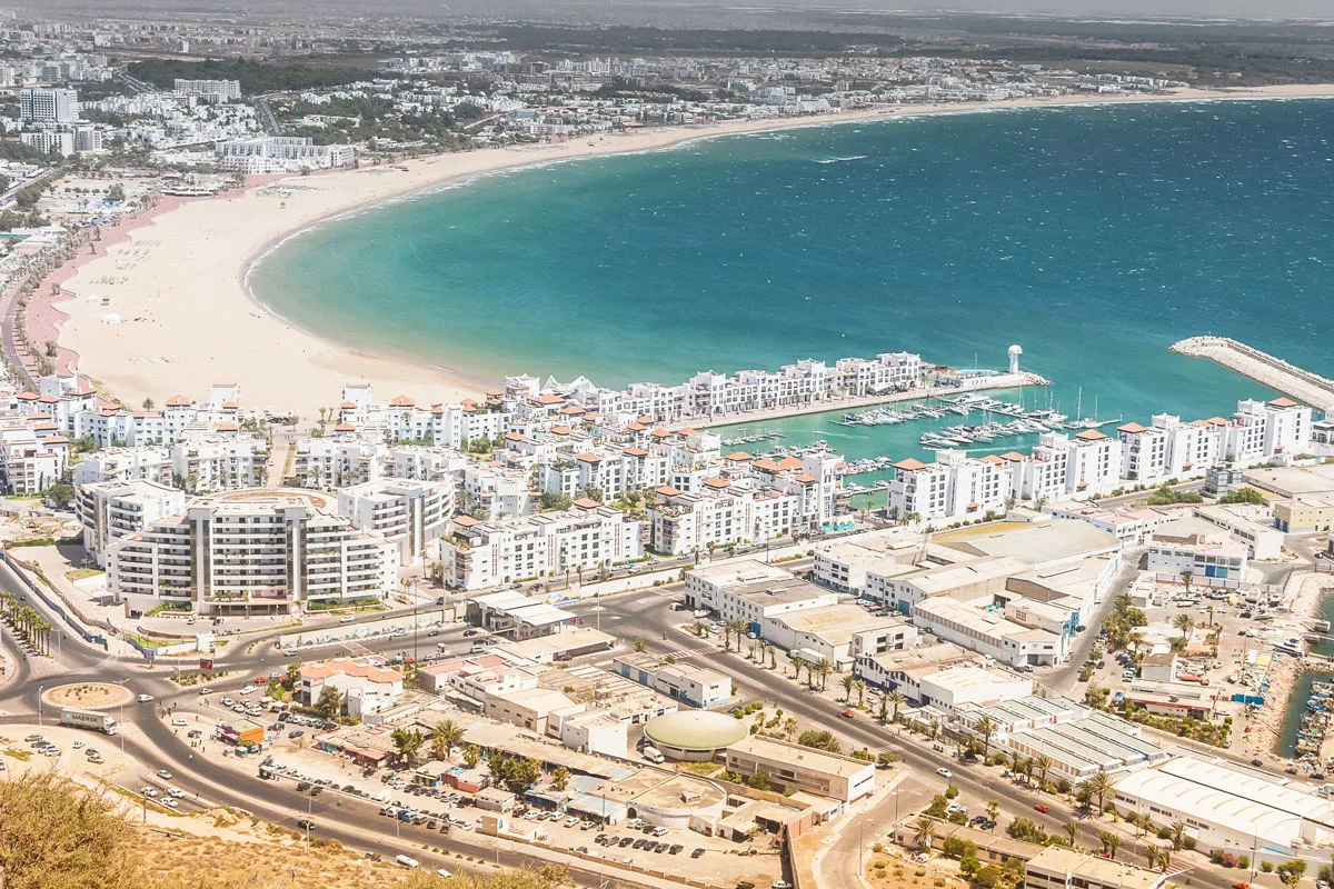 Looking over the blue bay of Agadir with resort buildings on the beach.
