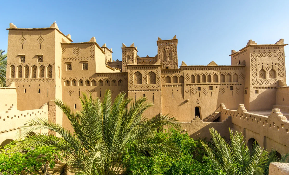 The mud brick Admridil Kasbah with lush palms in front in Skoura Morocco.