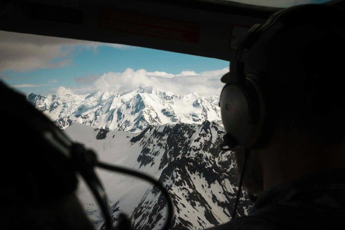 cockpit view of snow capped alaskan alps.  best wildlife and wilderness destinations provide an abundance of animals such as wild bears and bison moving freely.