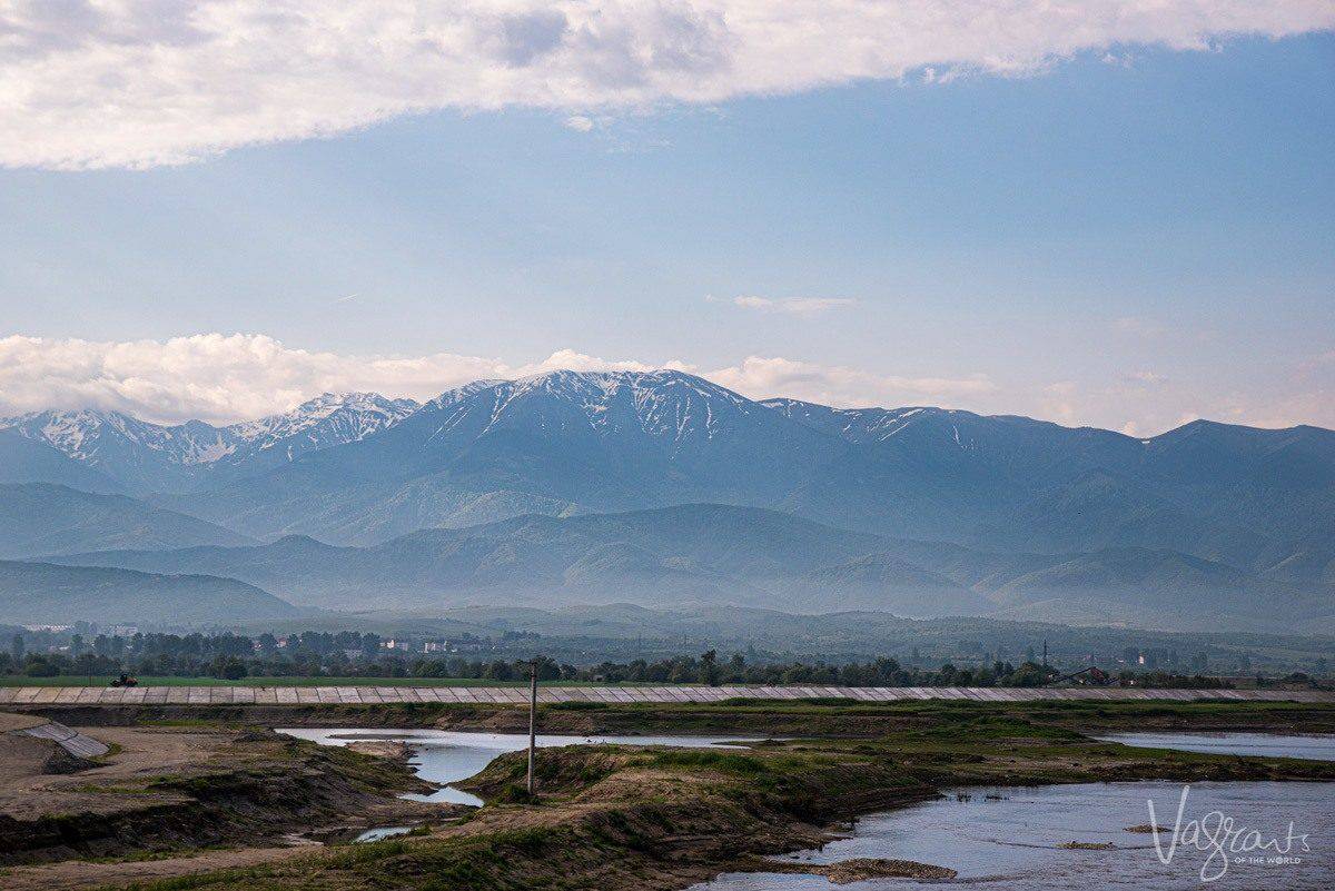 wooden walkway across wet lands backed by snow capped mountains. this is the place to visit if you are looking for the best wildlife and wilderness destinations