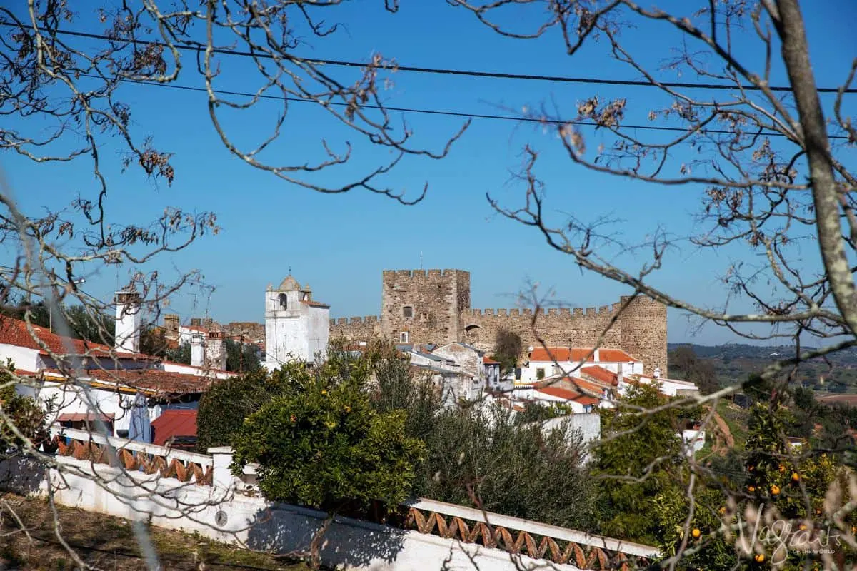 a view across white village to the castle of terena.  add this to your alentejo portugal itinerary.