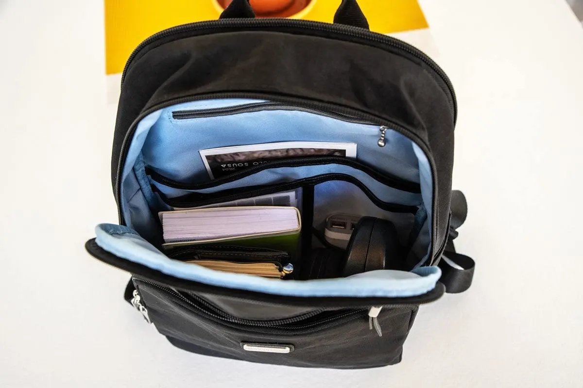 looking inside a back pack full of books and other travel items.