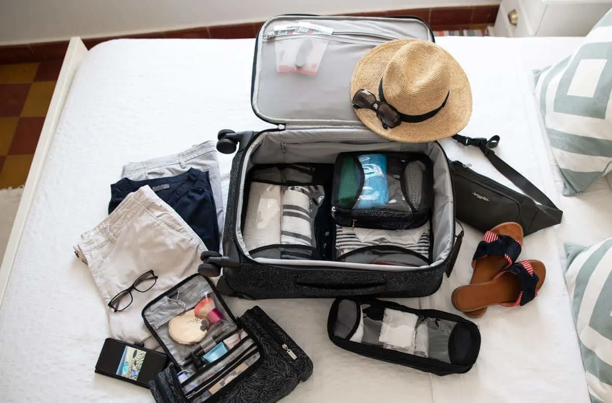 an open bag showing clothing items laid out for the next big vacation.  this little light weight four wheeled travel bag may be the ultimate choice for carryon