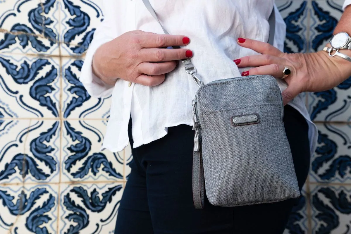 side view of a women wearing a grey cross body purse.  it is not easy to find the best purses for travel but baggallini seem to be doing a good job of producing what a women wants in a travel purse