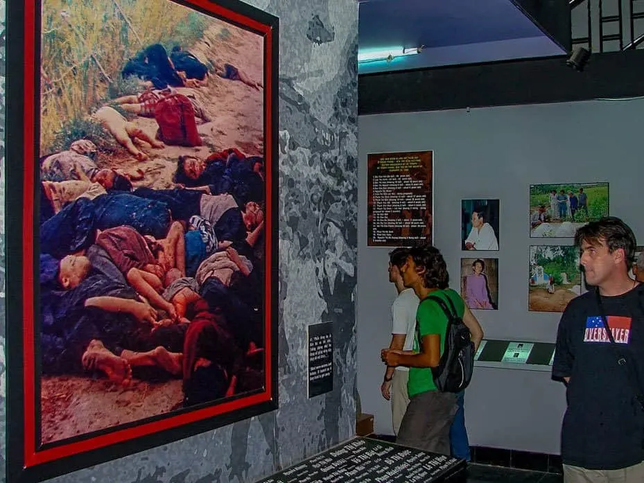 tourist looking at a photograph of dead vietnamese at the war remnants museum. this is the most popular and interesting things to do in Ho Chi Minh city
