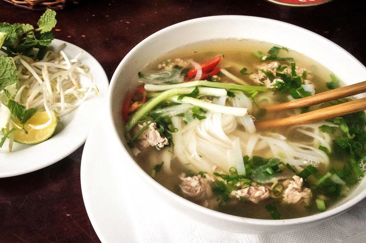 Bowl of pho with noodles, chop sticks and chicken. best street food in ho chi minh city.