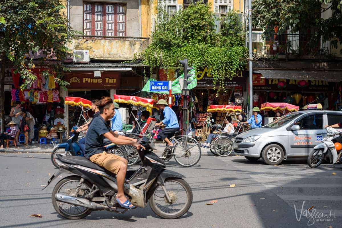 Men on scooters and bicycles in Hanoi Old Quarter. 