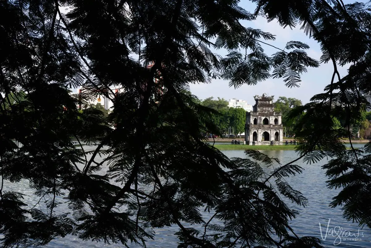 Temple framed by tree leaves in the middle of Turtle Lake Hanoi.