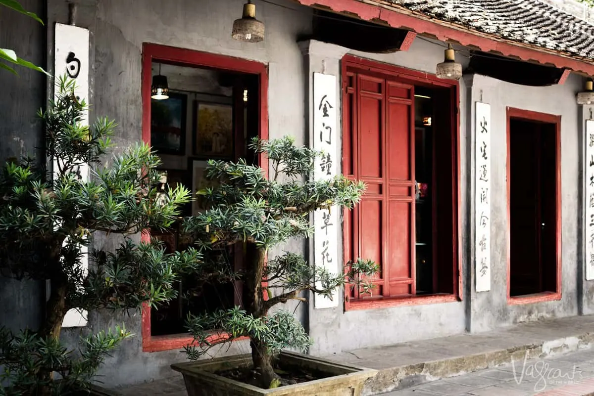 Bonsai outside red temple doors. 