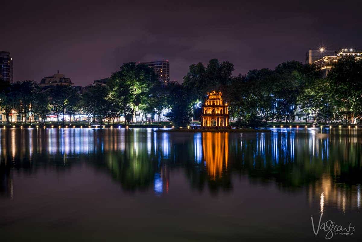 Turtle tower lit with golden light, spending time around this lake is the best thing to do in Hanoi at night.