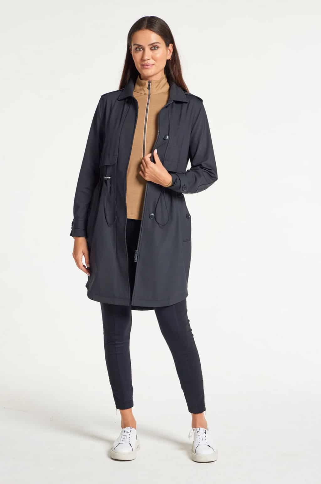 Attracive woman with dark hair modelling a dark coloured travel trench coat.