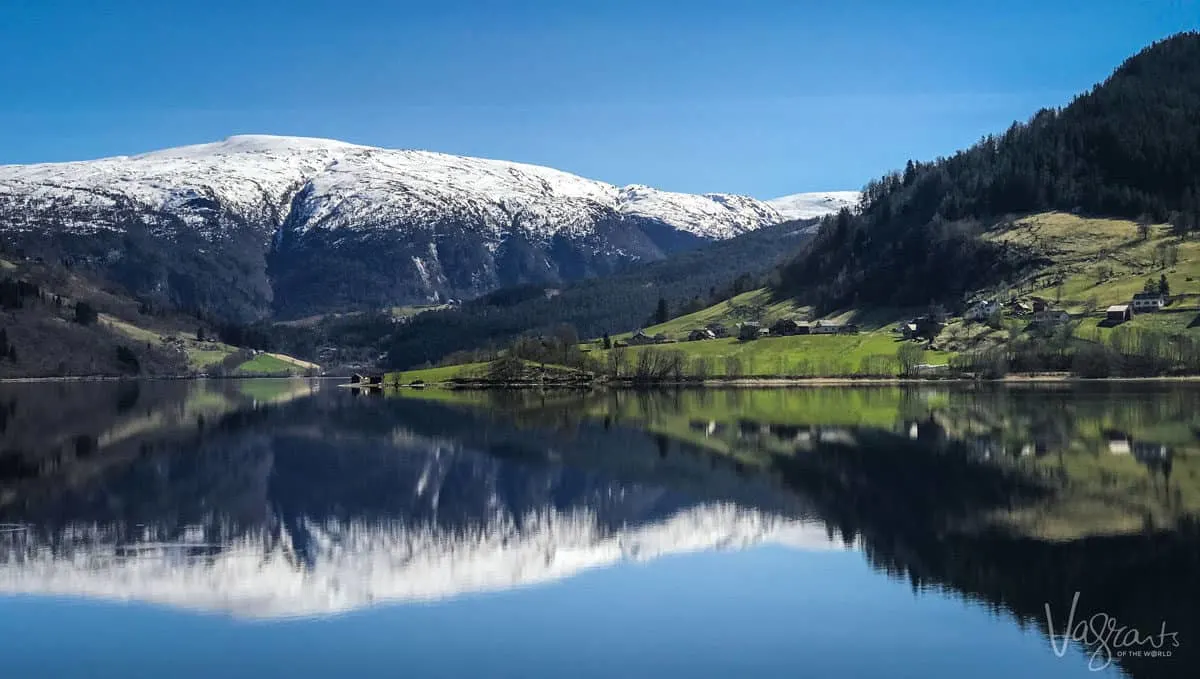 Snow capped mountain behind a fjord in Norway.