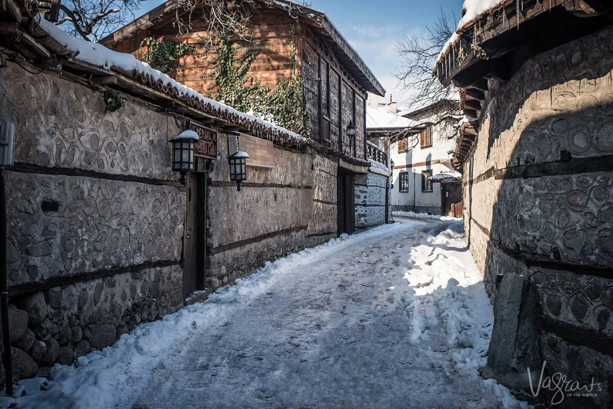 A snowy covered street with old stone buildings in Bulgaria. 