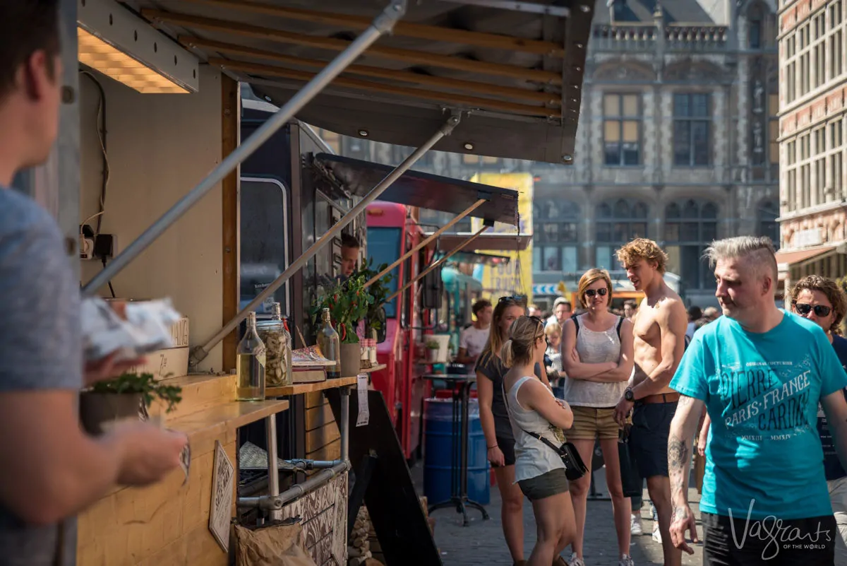 People walking past food truck vendors at the Ghent Food Truck Festival.