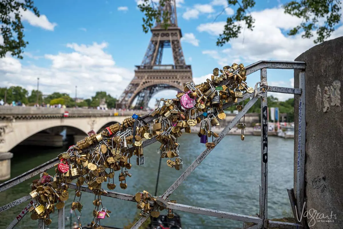 Love locks on a bridge with the Eiffel tower in the background. 
