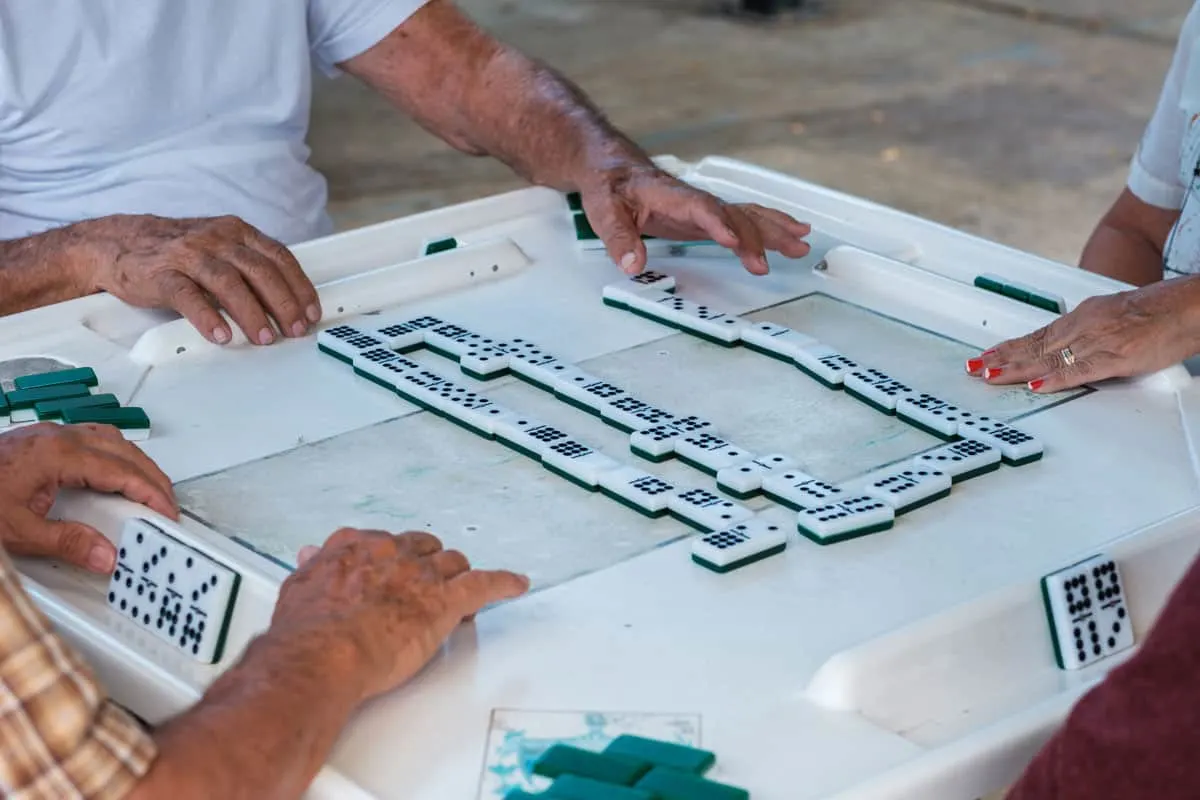 Hands around a dominoes game in Little Havana