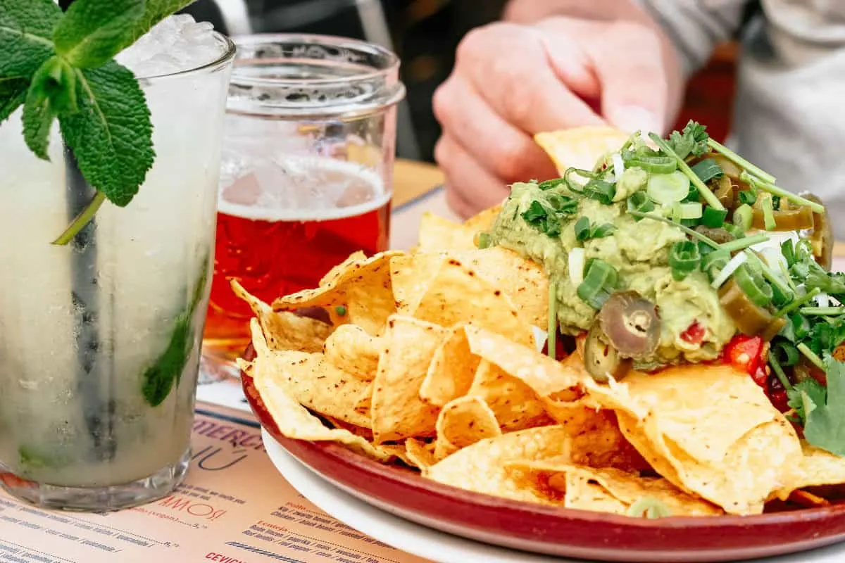 Bowl a nachos with a beer and a cocktail. 