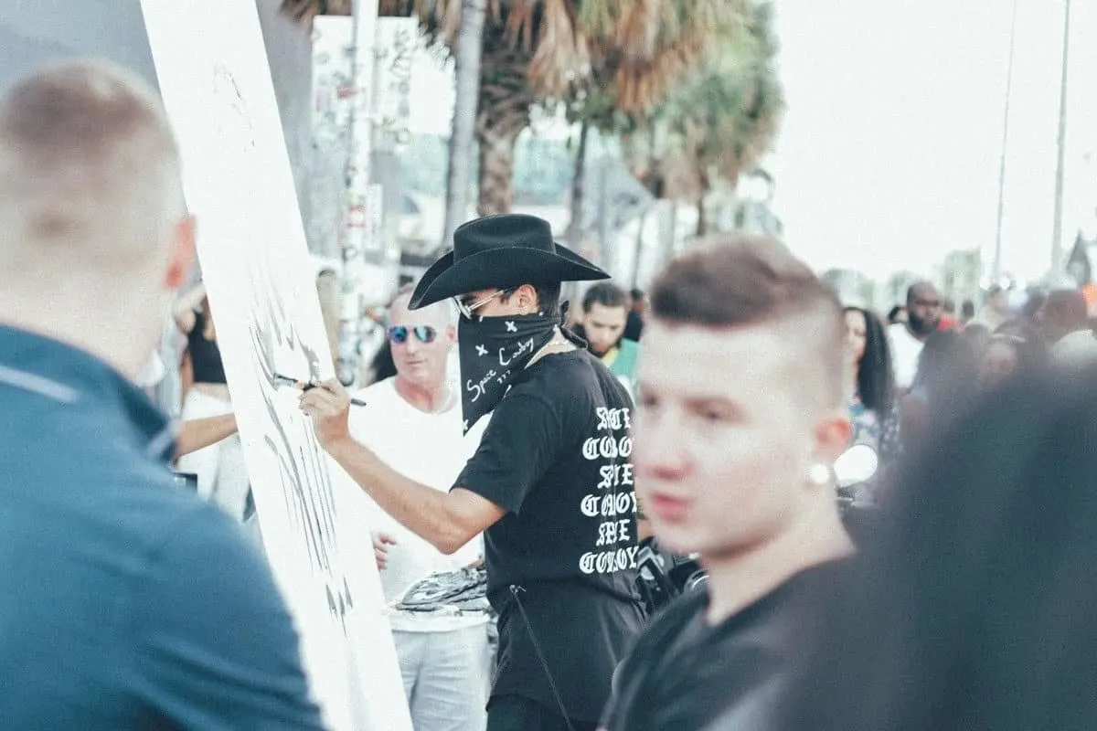 Artist painting among the crowd in the street in Wynwood Miami. The Wynwood Art Walk Block Party is free and happens every second Saturday