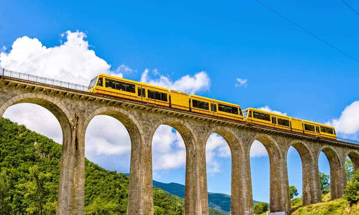 the yellow le train crossing the Juane Pont Gisclard, railway suspension bridge in the French Pyrenees