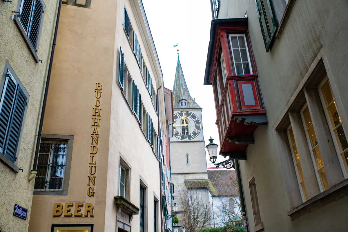 Narrow streets of Zurich with the church steeple on the skyline.