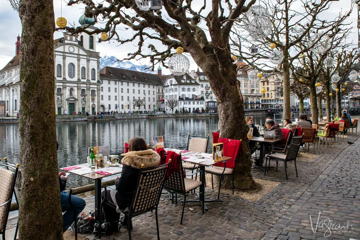 people sitting at outside cafes in Lucerne Switzerland in the middle of Old Town