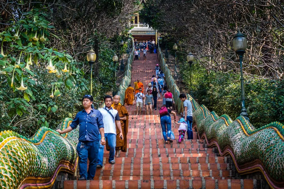 people walking down the 306 steps from the Wat Phra That Doi Suthep temple in Chiang Mai Thailand