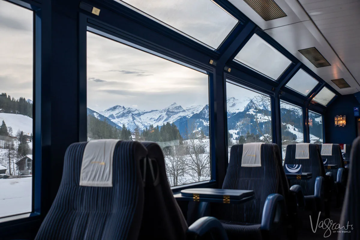 First class train carriage on the Panoramic Golden Pass Train with the snowy Swiss Alps on the horizon.