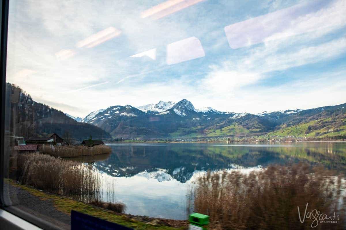 Swiss Alps reflected in a crystal blue lake viewed from the Golden Pass Train
