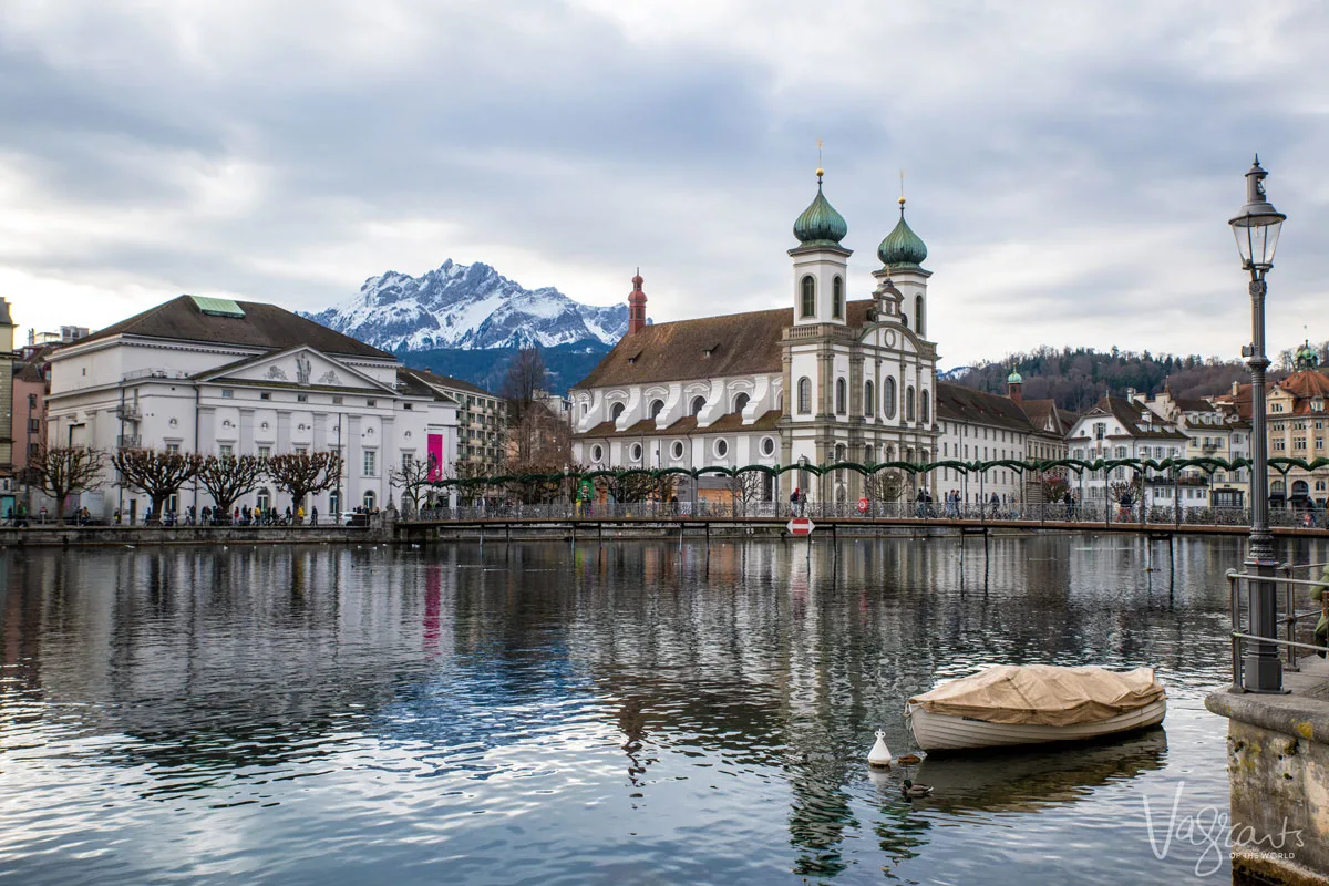 Old city of Lucerne over the river with the Swiss Alps in the background. 