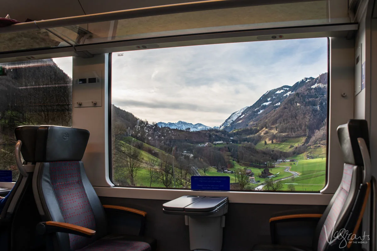 Luxury seats next to the train window and lush green Swiss countryside and the Swiss Alps between Interlaken Ost and Zweisimmen on the Interlaken Express, Golden Pass Line.