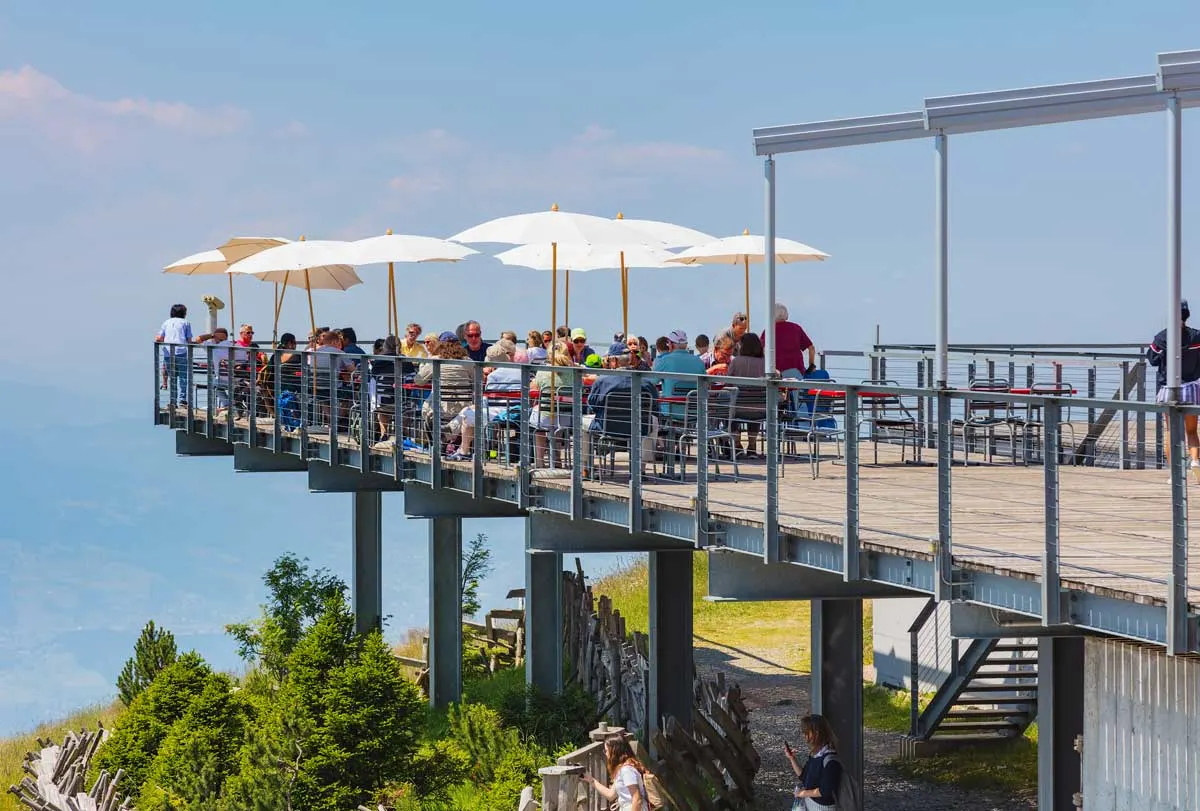 Tourists sitting at an outdoor cafe on the peak of Mt. Rigi in Switzerland in summer