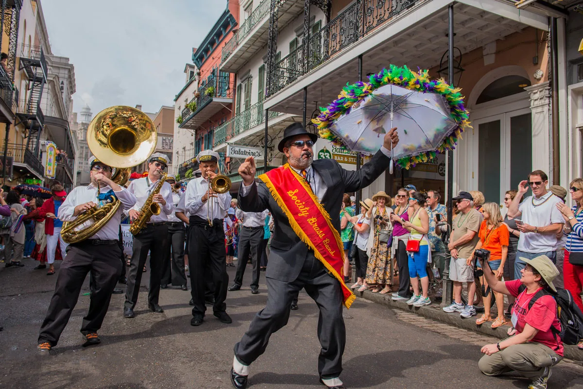 Brass band with band leader holding a colourful umbrella at the New Orleans French Quarter Festival