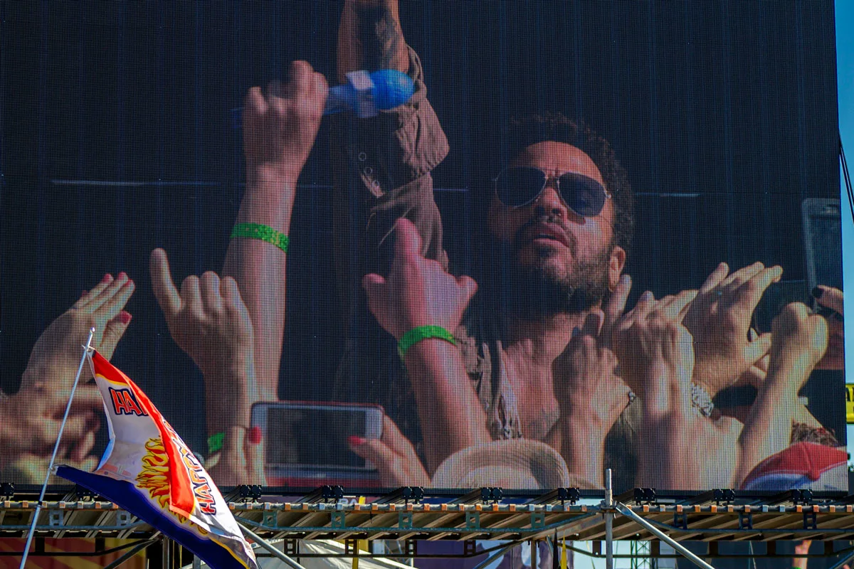 View of the big screen at the New Orleans Jazz festival with lenny kravitz and the crowd waving in the foreground