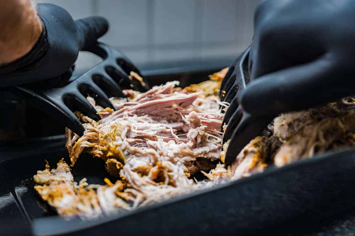 Close up of hands shredding pulled pork for the Crescent & BBQ festival in New Orleans