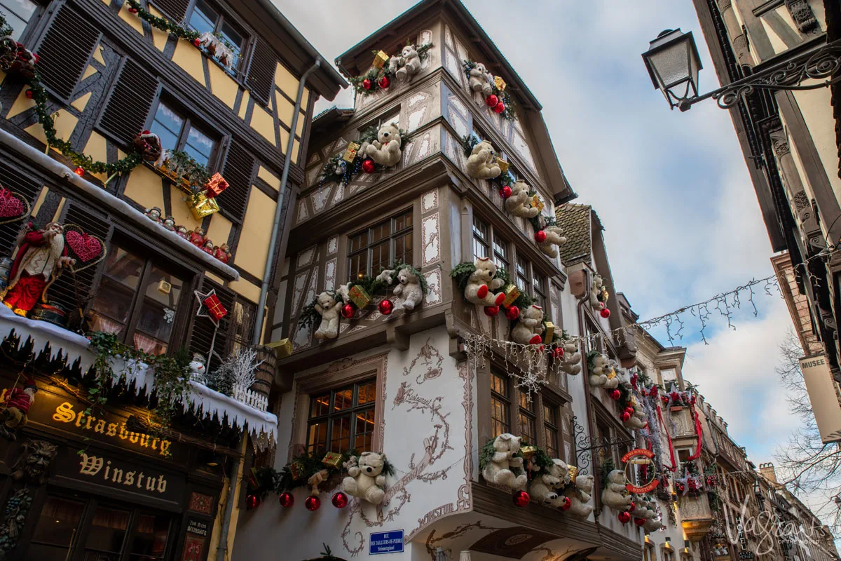 Looking up at the timber houses in Strasbourg old town covered with Christmas decorations and giant Christmas teddy bears.