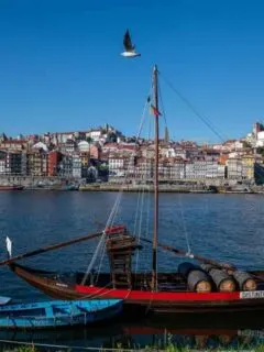 Old Port wine boats moored on the Douro River with Porto Old Town in the background across the river.