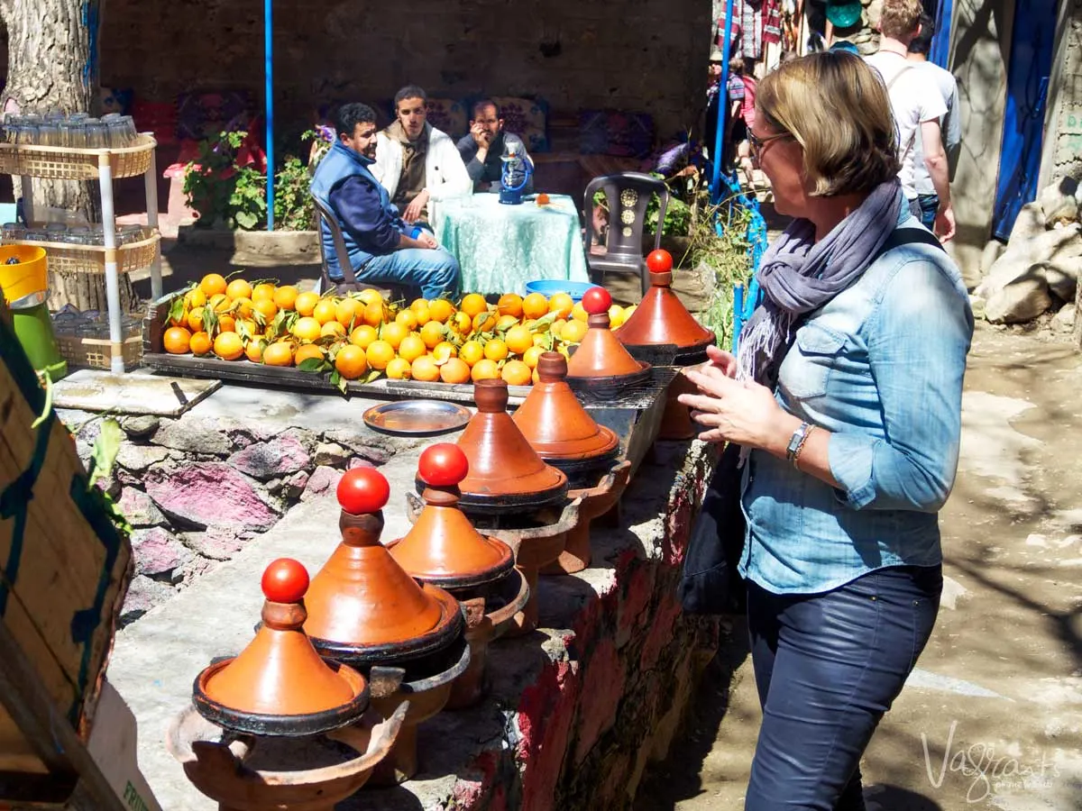 Woman on a day trip from Marrakech to the atlas Mountains choosing a tagine at the markets.