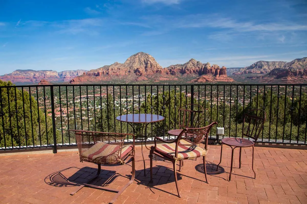 A terrace with a table and chairs overlooking the magificent red rock landscape of Sedona in Arizona. 
