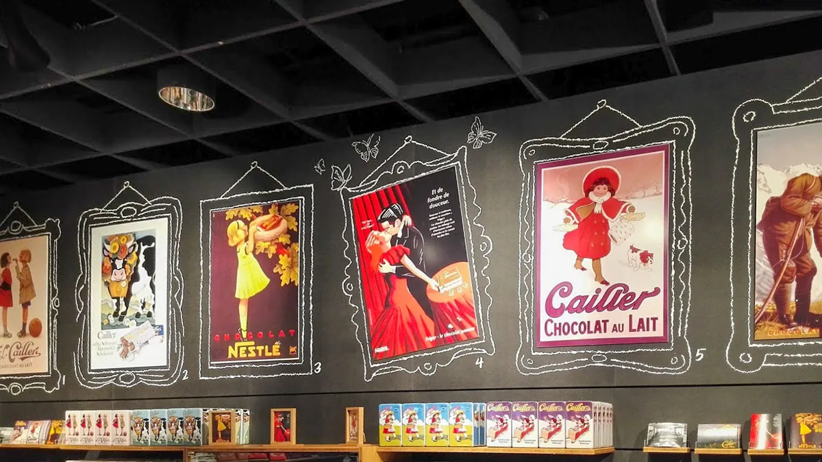 Old fashioned chocolate posters adorn the wall at Cailler Chocolate Factory