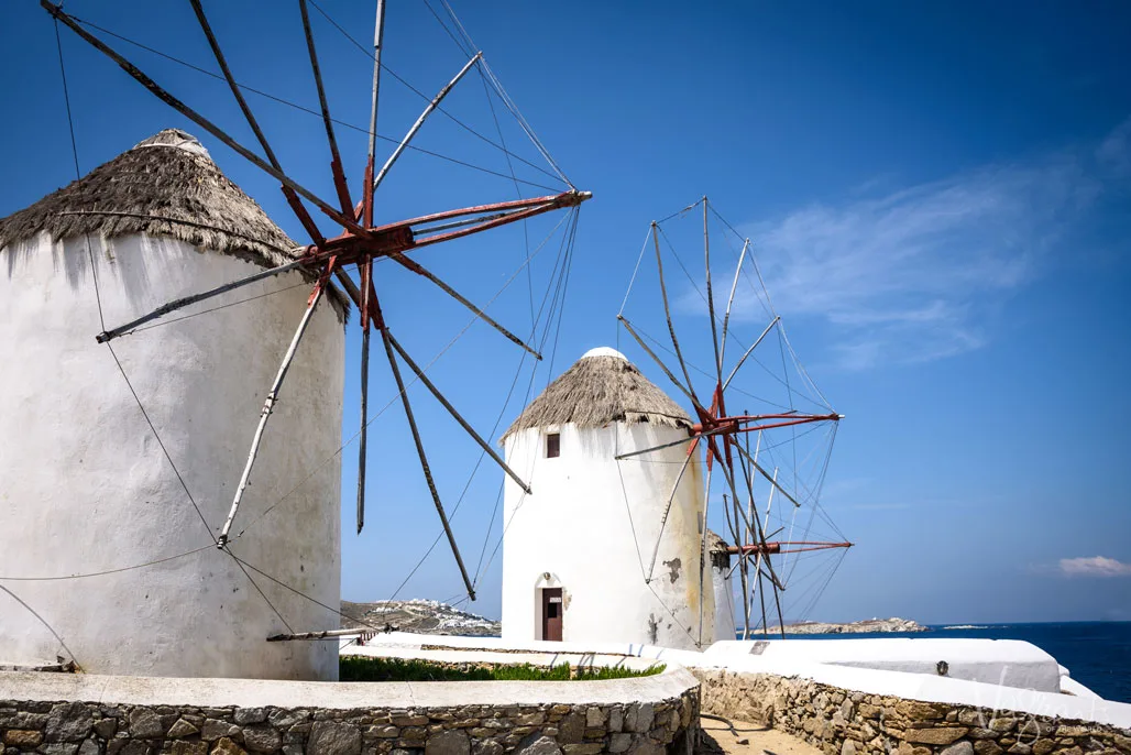 3 old windmills against a blue sky.