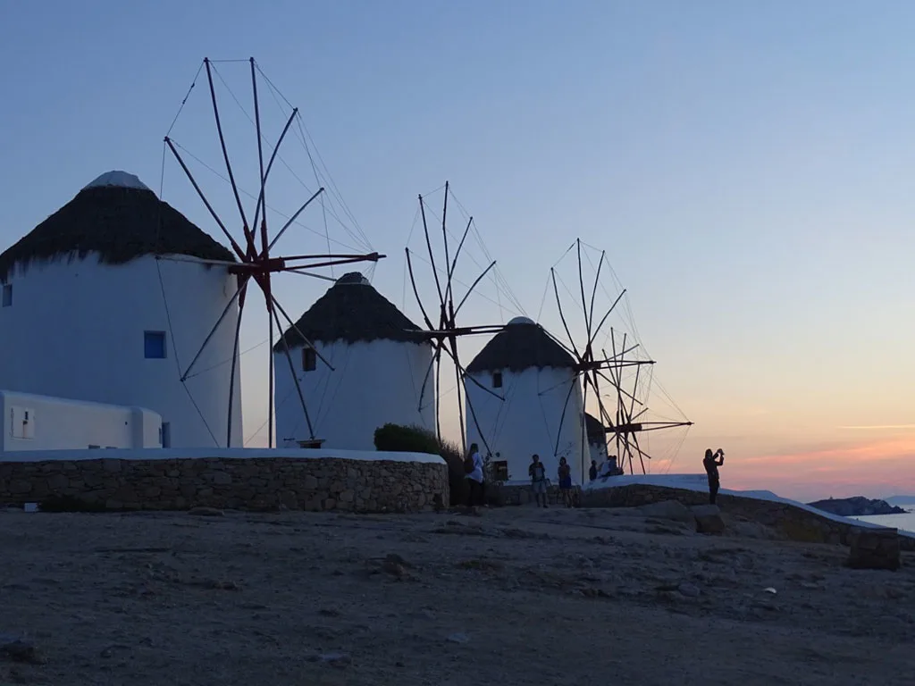 Photographers at Mykonos windmills enjoying sunset.