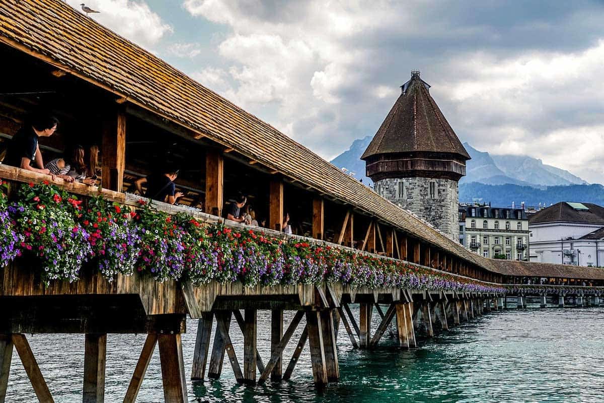 Flowers cascading down the sides of the old covered wooden walking bridge in Lucern.