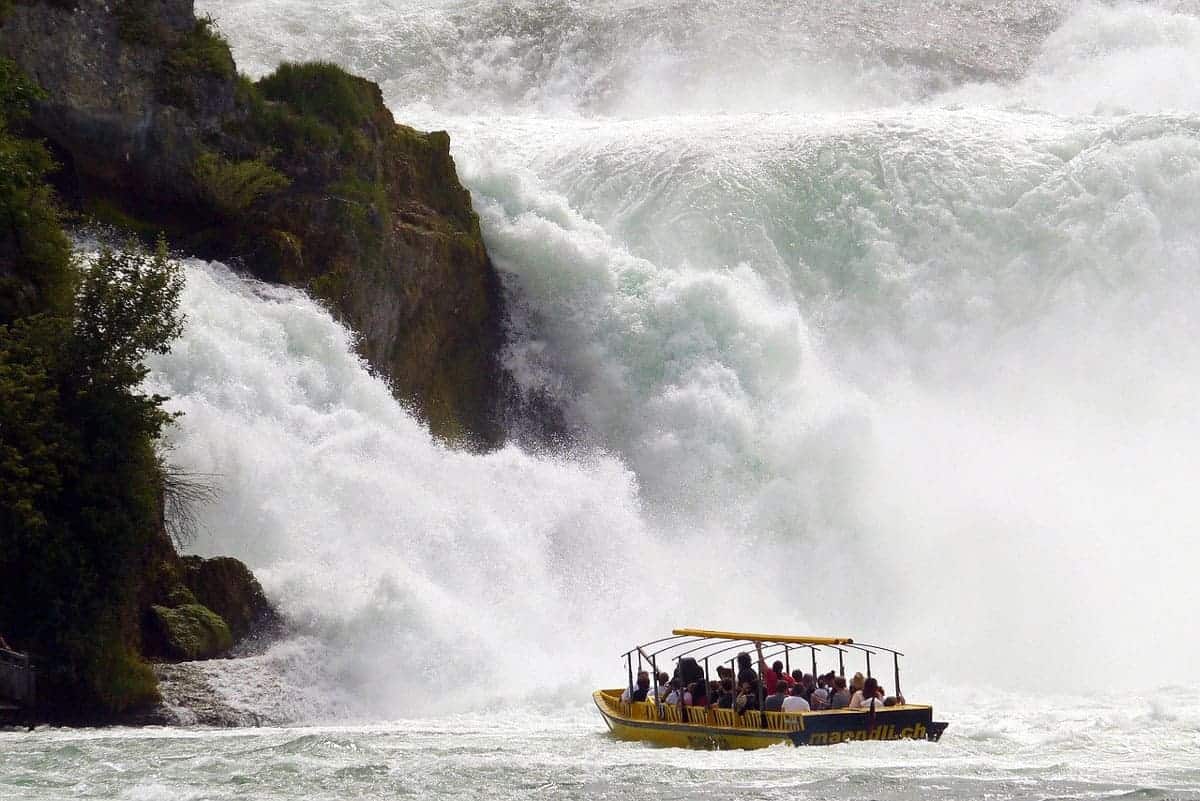 Tourist boat heading towards the spray and mist of the rushing Rhine Falls