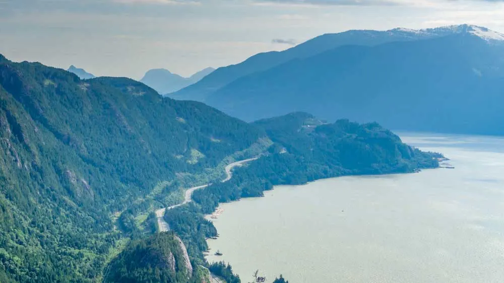 Canada road trip leads you along a winding road next to the lake below Squamish.