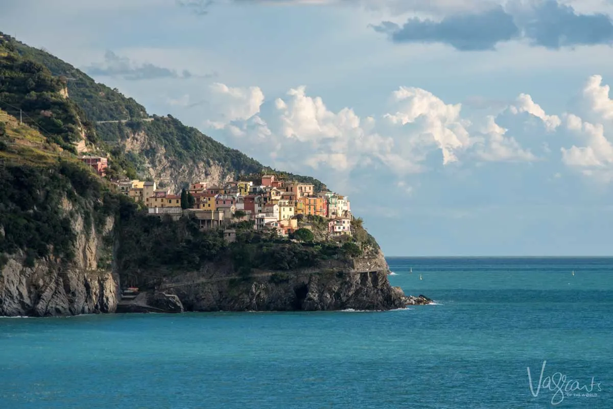 The town of Corniglia in Cinque Terre perched on th edge of a cliff overlooking the ocean.