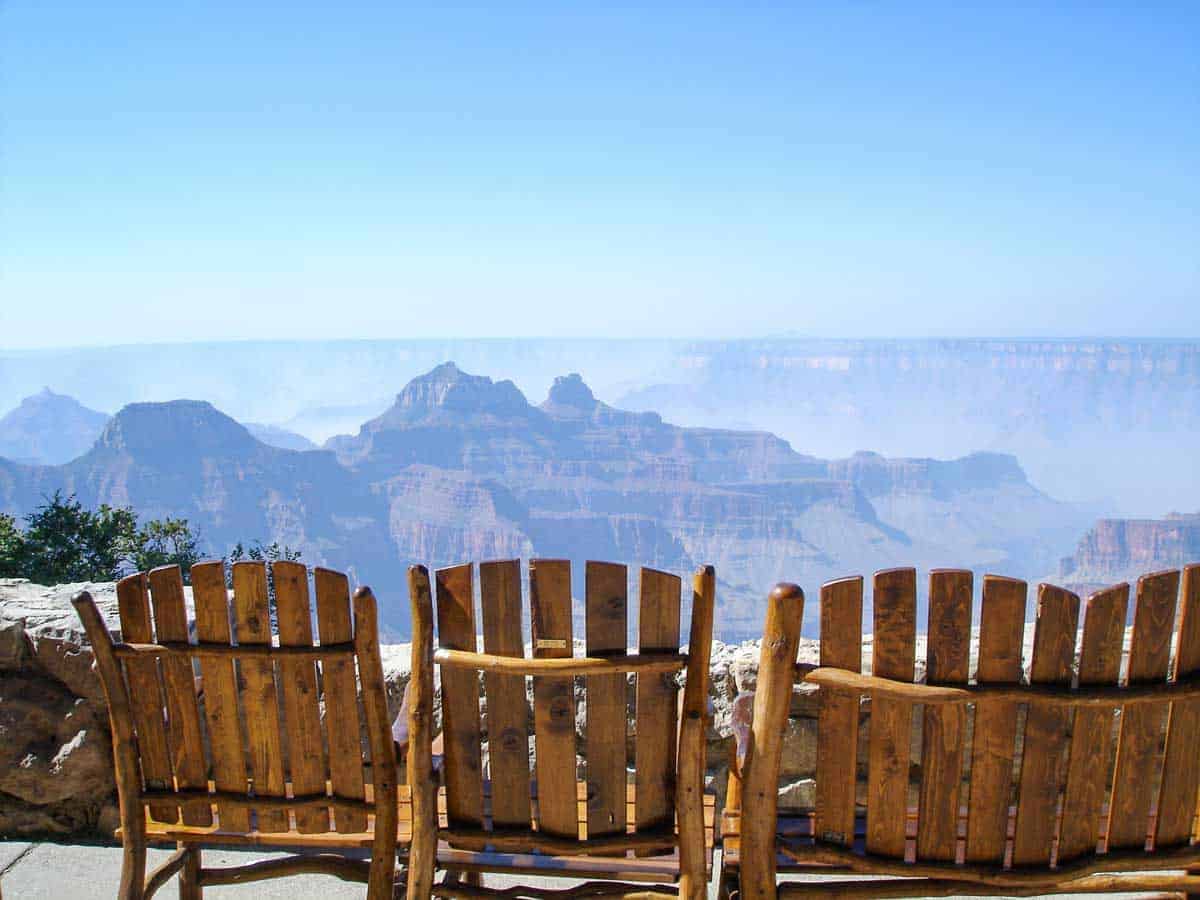 Wooden arm chairs at an overlook with views of the Grand Canyon.