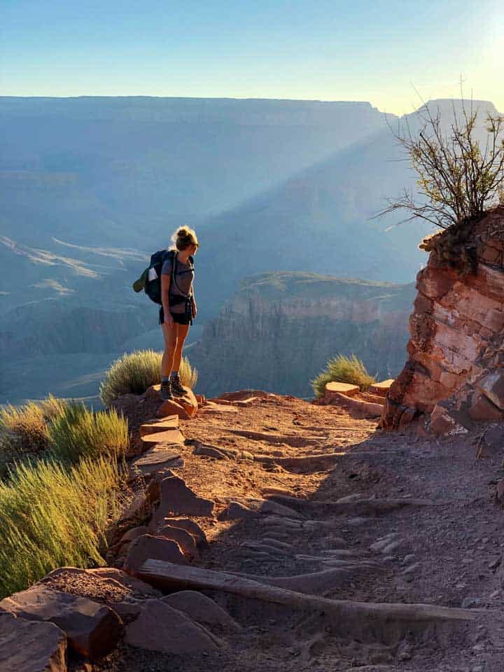 Female trekker looking back down the winding trails of the Grand Canyon.